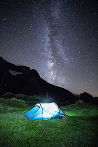 lighted blue tent on grass and milky way thumbnail