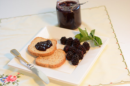 raspberry jam beside plate with bread and raspberries thumbnail