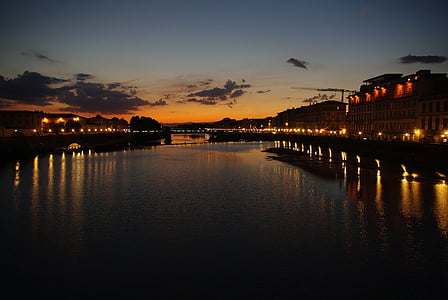 silhouette photography of body of waters and building during golden hour thumbnail