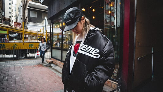 woman standing on the sidewalk with her hand on her jacket's pocket thumbnail