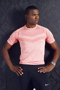 Man Wearing Pink Crewneck Shirt and Black Nike Shorts Standing thumbnail