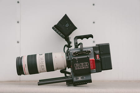 photo of black and white professional video camera beside white wall thumbnail
