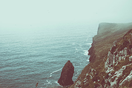 photo of rocky cliff and sea during daytime thumbnail