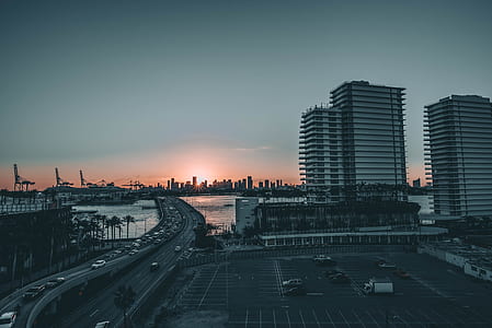 aerial photography of concrete bridge near buildings during golden hour thumbnail