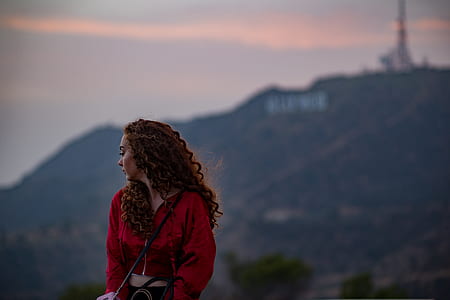 woman sitting near Hollywood sign during golden hour thumbnail