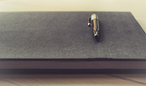 black click pen on top of book thumbnail
