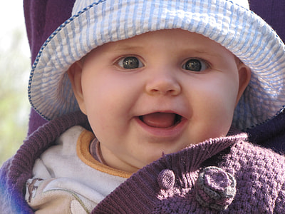 close up photography of baby with blue pinstriped hat during daytime thumbnail
