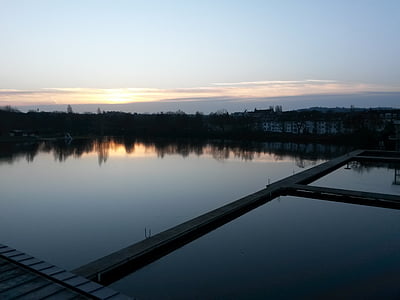 calm body of water under gray sky thumbnail