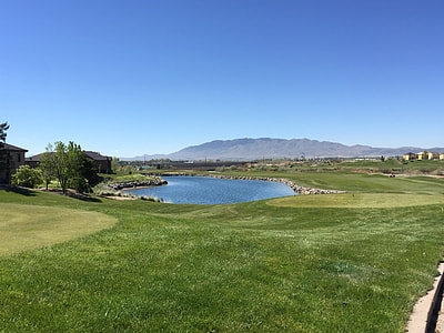 golf course with pond under blue sky thumbnail