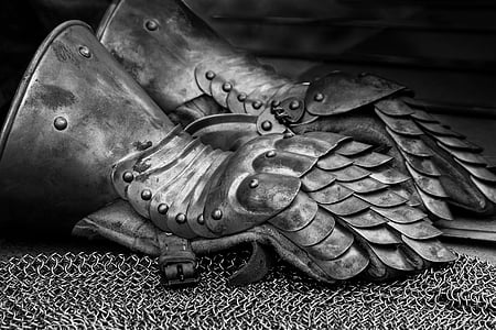 pair of metal gauntlet on chainmail grayscale photography thumbnail