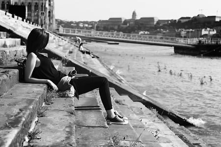 Woman on Black Shirt Sitting on Stairs in Front of River thumbnail