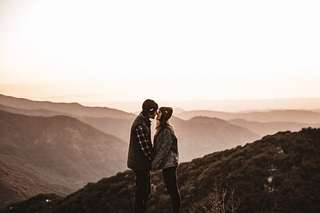 man and woman kissing on mountain range top thumbnail