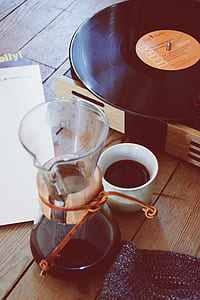 white ceramic mug with coffee inside beside black RCA vinyl record thumbnail