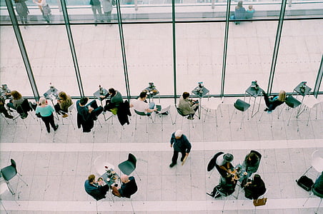 group of people gather while sitting in front of table high angle photograph thumbnail