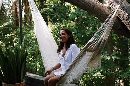 woman sitting on white hammock near brown tree thumbnail