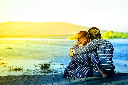man wrapping woman's shoulder on dock thumbnail