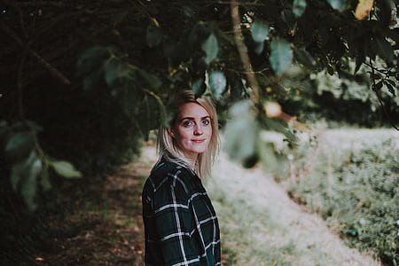 woman surrounded by green leaves in shallow focus photography thumbnail