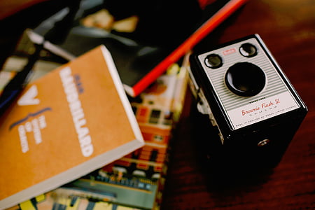black and white land camera beside book thumbnail
