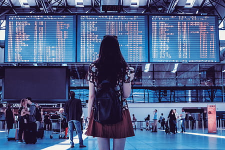 Young woman with bag checking flight timetable in international airport thumbnail
