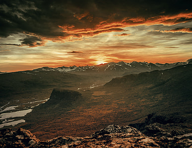 areal photography of mountain under white clouds and blue sky during golden hour thumbnail