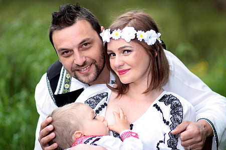 man hugging woman carrying baby while breastfeeding thumbnail