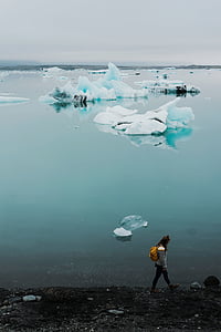 woman walking near body of water thumbnail