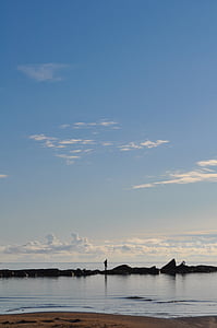 person standing on sea stack under white clouds thumbnail