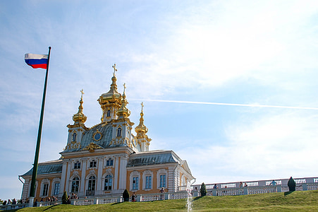 white and gold building in front of flag thumbnail