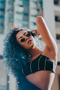 woman wearing black sports bra and gold-colored framed sunglasses thumbnail