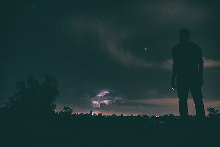 man standing on ground looking at sky during nighttime thumbnail