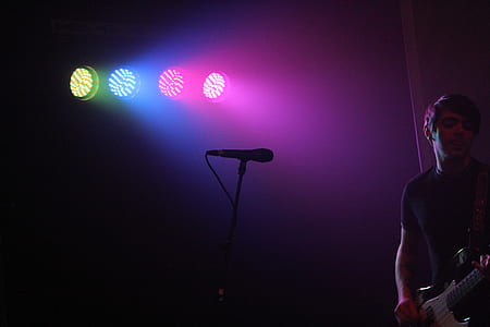 man standing beside microphone stand thumbnail