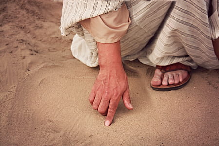 Person Wearing White and Gray Striped Dress Touching Brown Sand thumbnail