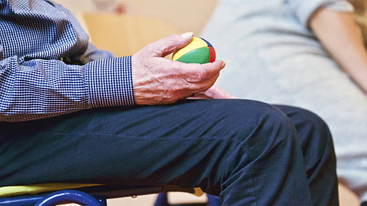 shallow focus photography of elderly man holding a ball thumbnail