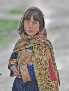 close up photography of a girl wearing blue and brown dress and scarf thumbnail