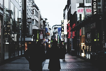 silhouette of couple walking between buildings thumbnail