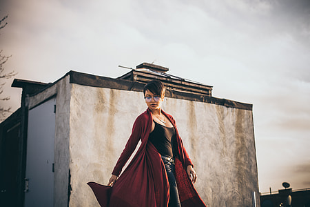 woman in black spaghetti strap top standing beside wall thumbnail
