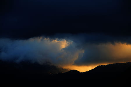 silhouette of mountain under white sky at nighttime thumbnail