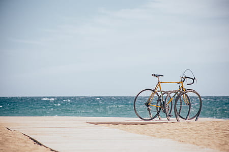 Bicycle parked on a boardwalk on the beach in sunshine thumbnail