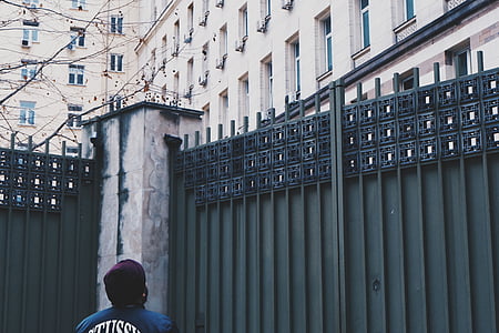 person standing beside steel gate thumbnail