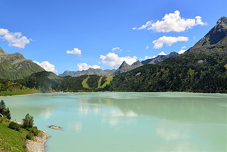 lagoon, mountains, and clouds during daytime thumbnail