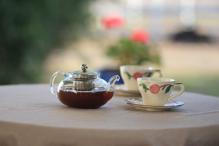 clear glass tea kettle and two floral ceramic cups thumbnail