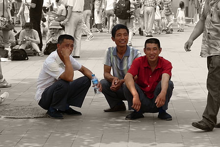 three men crouching on sidewalk thumbnail