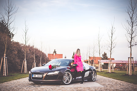 Woman in Pink Coat Standing Next To a Supercar thumbnail