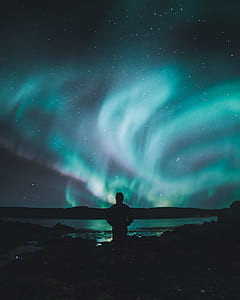 man looking at Aurora Borealis light outdoor thumbnail