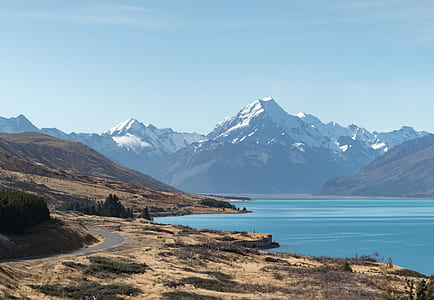 ocean near mountains under blue sky during daytime thumbnail