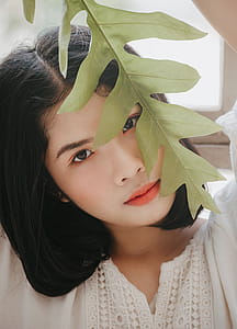 Close-Up Photography of a Woman Near Leaves thumbnail