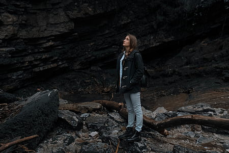 woman standing on rocks looking up thumbnail
