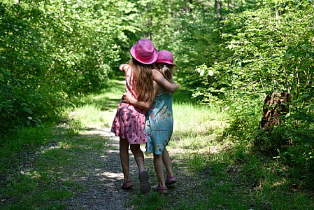two women wearing pink hats hugging each other thumbnail