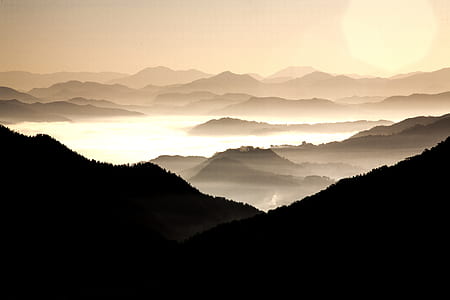 silhouette of mountain under clouds at daytime thumbnail