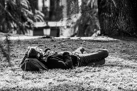 grayscale photo of man lying on grasses thumbnail